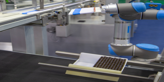 Tray aus PP-Platten für automatische Produktion von Pharma- und Kosmetikprodukten 640 320 Ein Tray aus PP Hohlkammerplatten HKP wird automatisiert mit einem Roboterarm mit Metalltuben bestückt