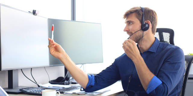 Happy young male customer support executive working in office.