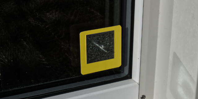 Klebepatch gelb mit aufgeklebtem Pin zum befestigen außen von einem Schutzsystem für Fenster auf Baustellen