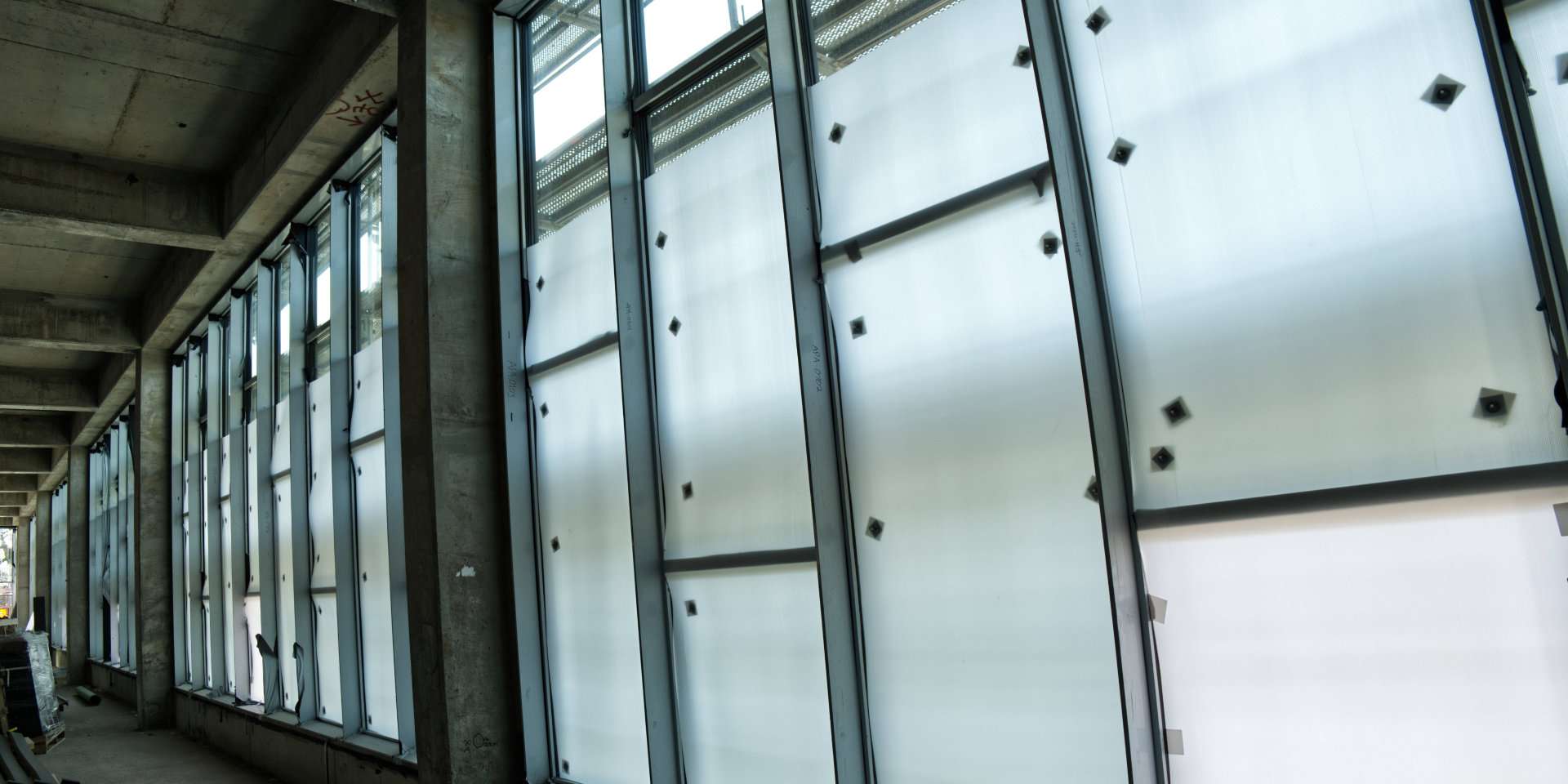 Fenster schützen auf Baustellen Fensterfront mit montierten Schutzplatten