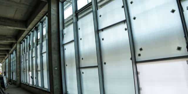 Fenster schützen auf Baustellen Fensterfront mit montierten Schutzplatten